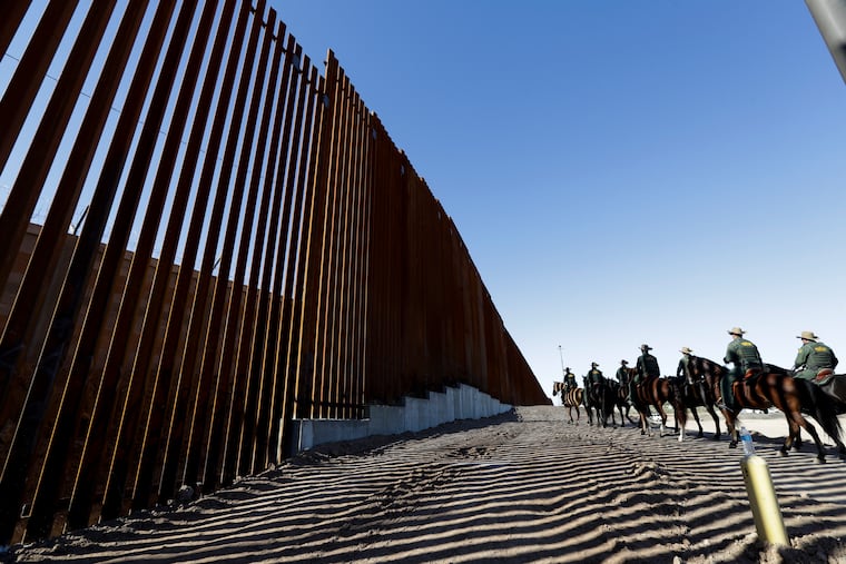 Mounted Border Patrol agents ride along a newly fortified border structure in Calexico, Calif., in 2018, shortly before President Trump was to visit and tour this portion of barrier.