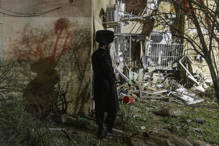 A Jewish orthodox man surveys a site where a missile from Iran hit in the city of Arad, southern Israel, on March 22. MUST CREDIT: Kobi Wolf/Bloomberg