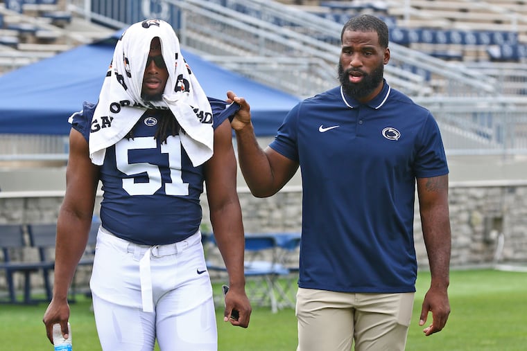 Penn State football defensive line coach Deion Barnes as a talk with tackle Hakeem Beamon earlier this season. Under Barnes, the Nittany Lions have one of the best defensive fronts in college football.