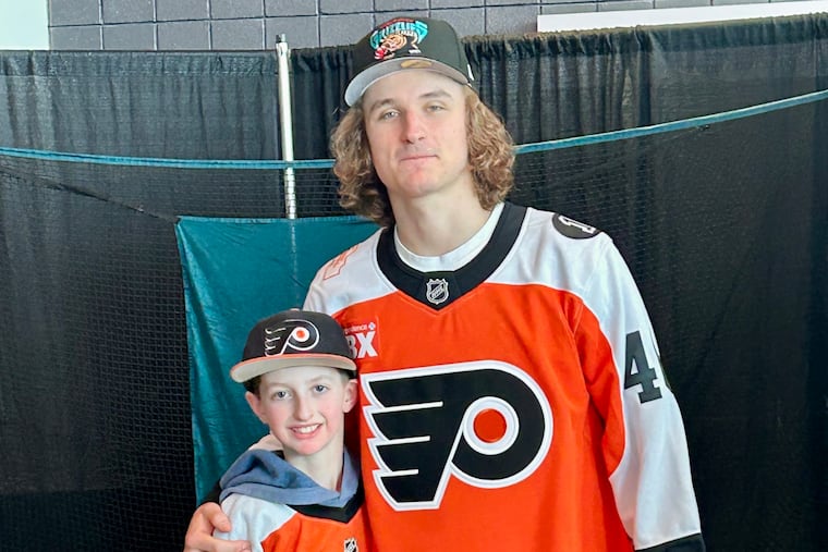 Shane Temple, 10, gets his Flyers jersey signed by center Trevor Zegras during a February charity event.