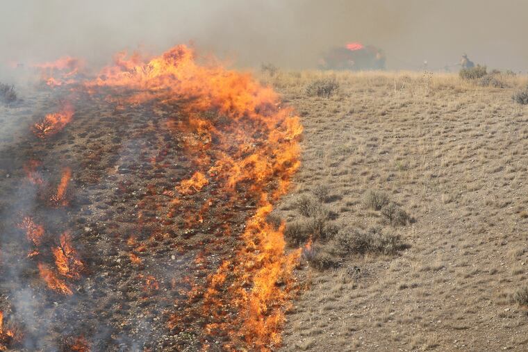 Firefighters battle a brush fire near Shaggy Mountain Road in Herriman, Utah on Sept. 15, 2018.