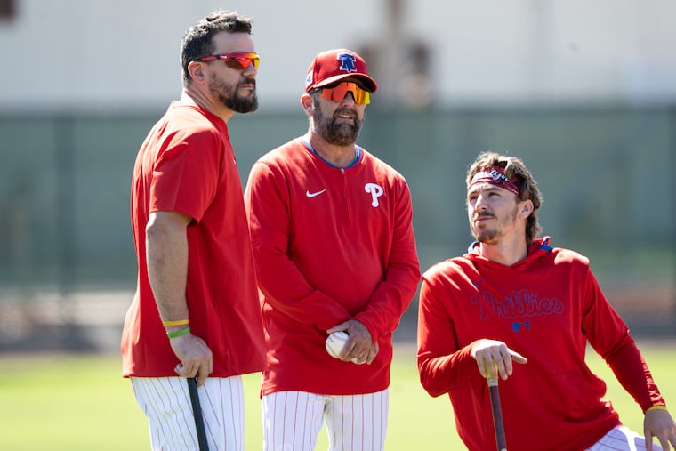 Phillies’ hitting coach Kevin Long, center, has worked with Kyle Schwarber, left, for the past four years and previously with the Nationals. Bryson Stott is at right.