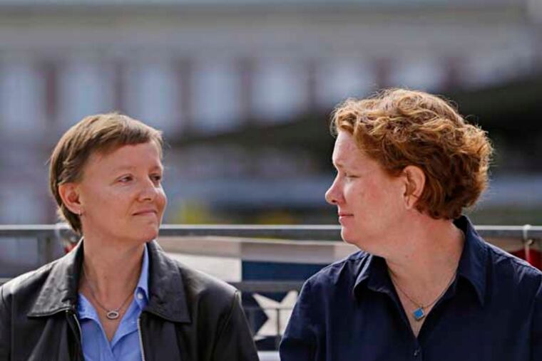 Plaintiffs Isabelle Barker, left, and her spouse Cara Palladino look at each other during a news conference, Thursday, Sept. 26, 2013, near Independence Hall in Philadelphia. Cara Palladino and Isabelle Barker, who were legally married in Massachusetts and moved to Pennsylvania, filed a federal lawsuit Thursday aiming to overturn the 1996 amendment to a state law stating same-sex marriages, including those recorded elsewhere, are not legal within the state.(AP Photo/Matt Rourke)