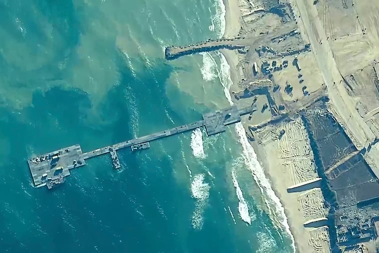 The image provided by U.S, Central Command, shows U.S. Army soldiers assigned to the 7th Transportation Brigade (Expeditionary), U.S. Navy sailors assigned to Amphibious Construction Battalion 1, and Israel Defense Forces placing the Trident Pier on the coast of Gaza Strip in mid-May.