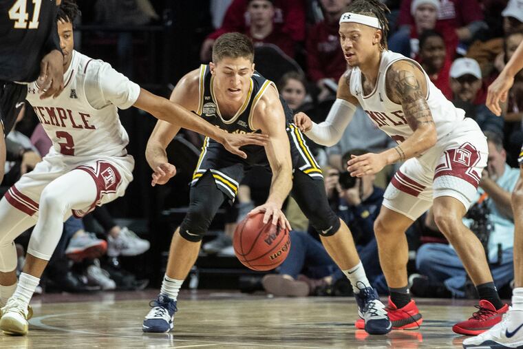 Villanova guard Collin Gillespie, center, tries to dribble through the defense of Temple guards James Scott, left, and Alani Moore II, right.