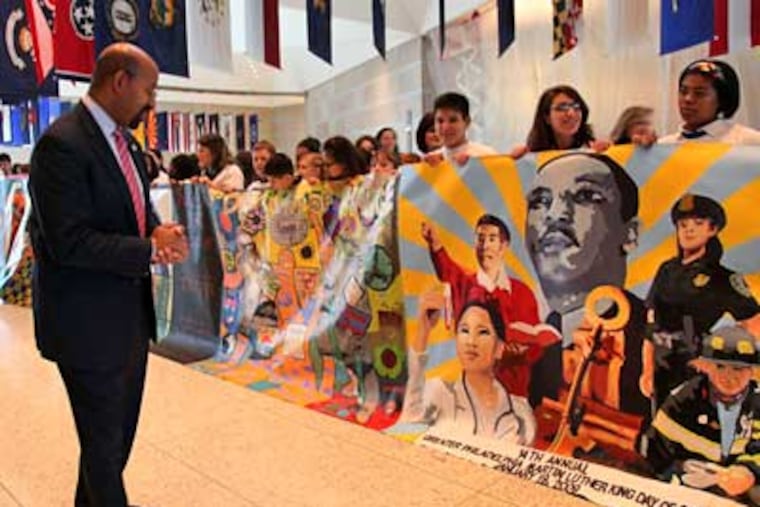 Mayor Michael Nutter examines a mural made by the Philadelphia Mural Arts Program before the Martin Luther King Day of Service press conference at the National Constitution Center on Wednesday. (Laurence Kesterson / Staff Photographer)