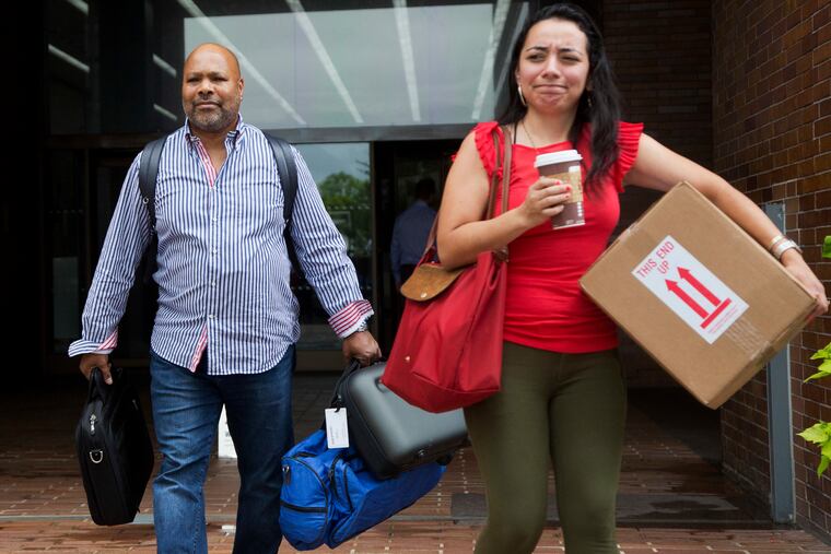 Two New York Daily News staffers leave the newspaper's office on Monday after being laid off.