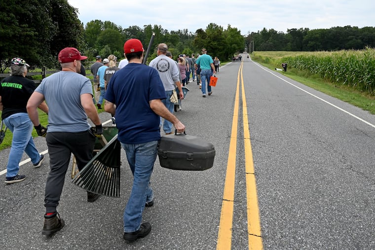Members and volunteers head out from Fellowship Bible Church Sunday, walking down closed roads to help clean up the property of neighbors following the destruction from a tornado spawned by the remnants of Hurricane Ida.