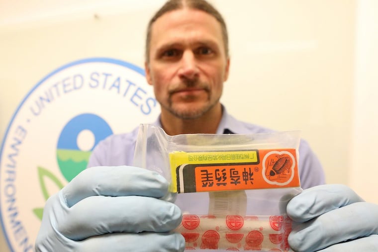 Chad Schulze, EPA pesticide enforcement officer, displays one of the banned pesticides that Amazon was selling online. (Greg Gilbert / Seattle Times / TNS)