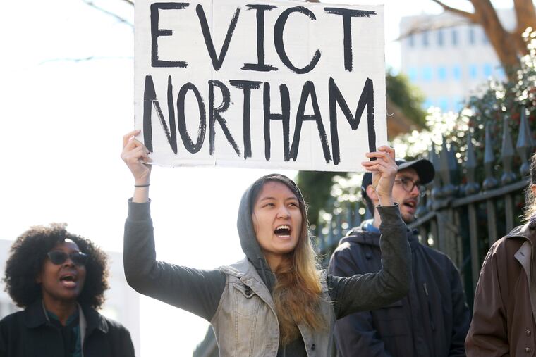 Geraldine Mabagos, of Richmond, Va., holds a sign during a protest in Richmond on Monday, Feb. 4, 2019, calling for Gov. Ralph Northam to resign. Northam has rebuffed widespread calls for his resignation after a racist photo surfaced Friday in his 1984 medical school yearbook page. (Shelby Lum / Richmond Times-Dispatch via AP)