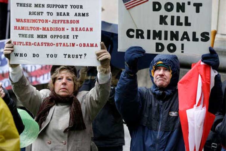 Betty and Robert Bailey of Millstone Township, N.J., hold signs during a Second Amendment rally outside the Statehouse in Trenton. (Mel Evans / Associated Press)