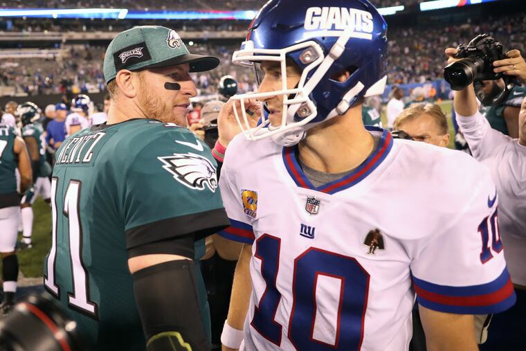 Eagle quarterback Carson Wentz talks with New York quarterback Eli Manning after the game that the Eagles won 34-13. The Philadelphia Eagles play the New York Giants at Metlife Stadium on Thursday October 12, 2018. MICHAEL BRYANT / Staff Photographer