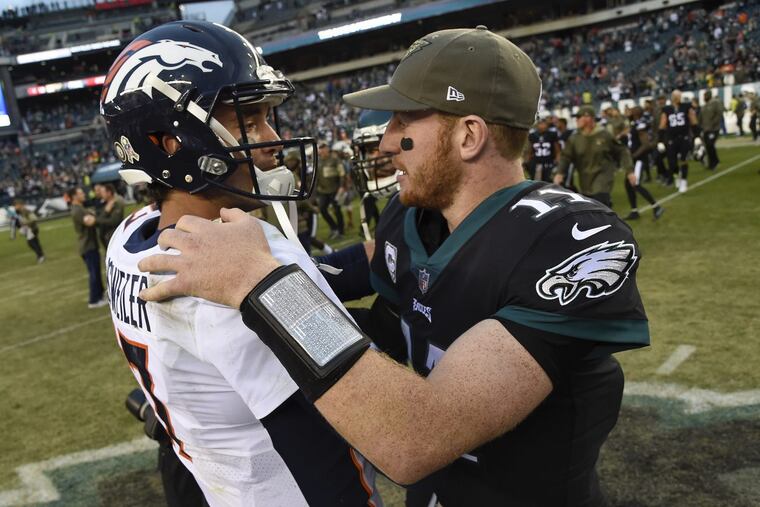 Eagles quarterback Carson Wentz meets Broncos quarterback Brock Osweiler after the Eagles’ 51-23 win over the Broncos on Sunday.