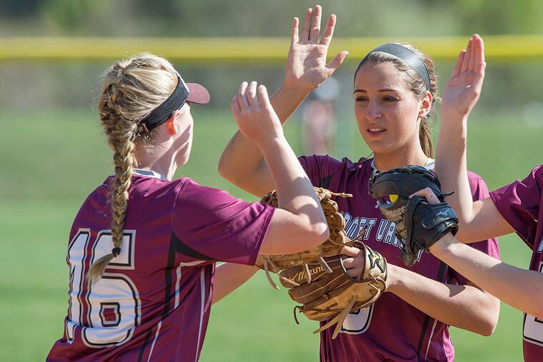 Garnet Valley seniors Sam Tomasetti (right) and Reva Alderman high five before the start of an inning against Penncrest.