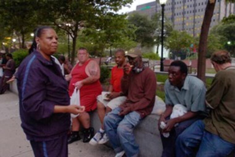 Veronica Joyner, chief executive officer of Mathematics, Civics and Sciences Charter School, talks with homeless men at JFK Plaza. She says she is determined not to halt the feeding program.