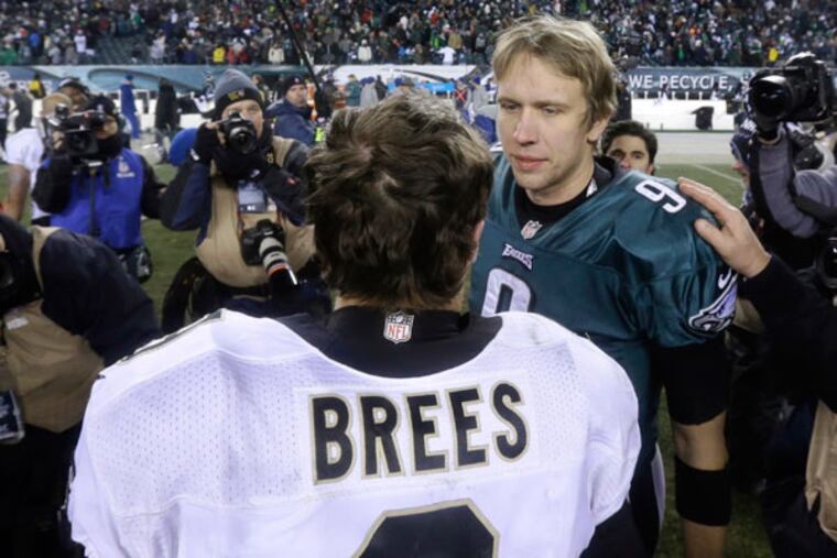 Drew Brees and Nick Foles meeting after the Saints defeated the Eagles in a January 2014 playoff game.
(Julio Cortez / AP)