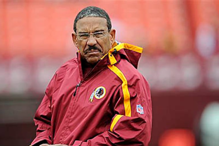 This is an Oct. 18, 2009, file photo showing Washington Redskins offensive consultant Sherman Lewis watching his team warm-up before an NFL football game against the Kansas City Chiefs, in Landover, Md. (AP Photo/Nick Wass, File)
