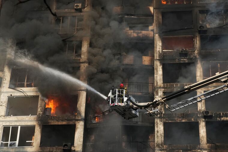 Firefighters work in an apartment building damaged by shelling in Kyiv, Ukraine on Tuesday.