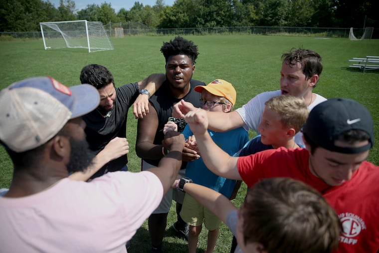 Boys huddle after a soccer activity during the weeklong Experience Camp at Camps Equinunk and Blue Ridge in Equinunk, Pa. The free program is for children who have lost a parent, sibling, or caregiver.