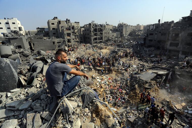 A man sits on the rubble overlooking the debris of buildings that were targeted by Israeli airstrikes in the Jabaliya refugee camp, northern Gaza Strip on Nov. 1. The White House says Israel has agreed to put in place four-hour daily humanitarian pauses in its assault on Hamas in northern Gaza.