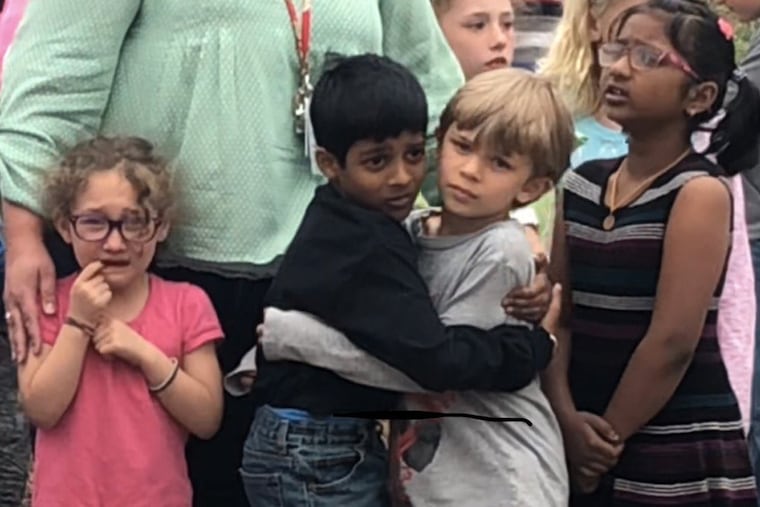 Young students embrace after a shooting at a charter school in Highlands Ranch, Colo., on Tuesday. One student was killed and eight others were injured.