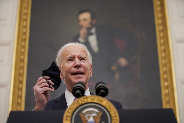 President Joe Biden holds a protective mask while speaking about his administration's COVID-19 response on Thursday.