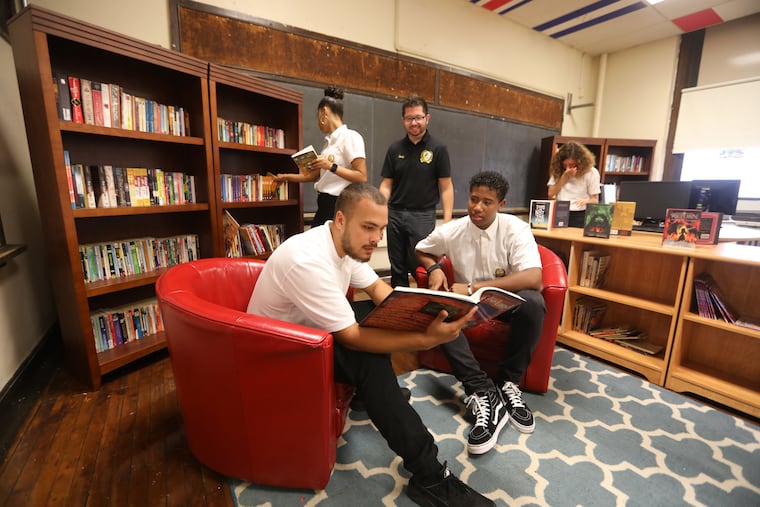 Teacher Eric Cruz (center) with (clockwise from left) seniors Michael Lugo, Brietney Vega, Britney Rivera and Manny Rivera in the library that engineering students are creating at Kensington High School.
