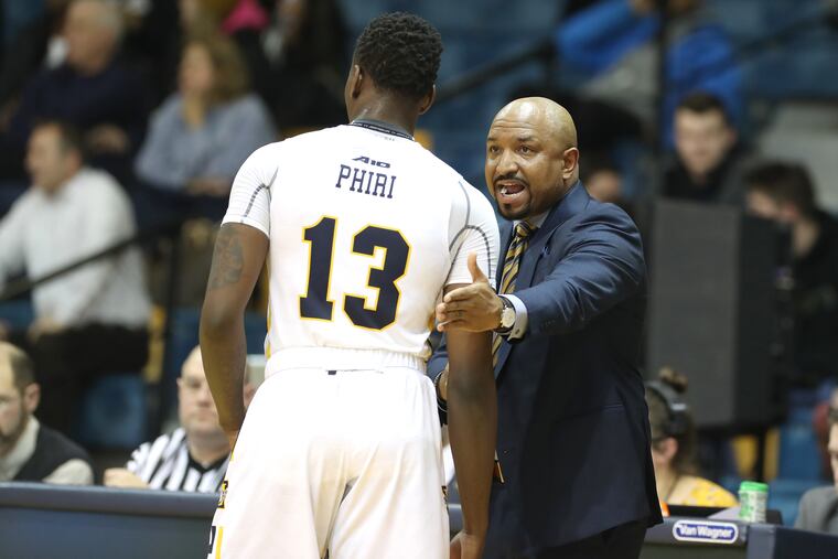 Head Coach Ashley Howard, right, talks to Saul Phiri of La Salle during their game against UMass.