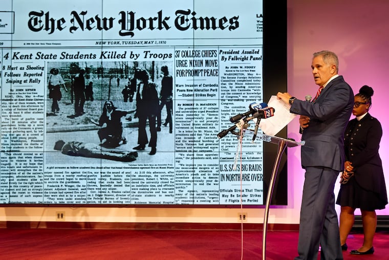 District Attorney Larry Krasner displays an image of the front page of the New York Times in 1970, comparing sending troops to Kent State to the action President Donald Trump took Monday in deploying the National Guard to the streets of Washington D.C.