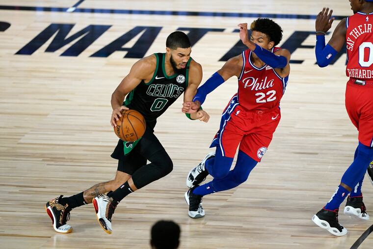 The Celtics' Jayson Tatum (0) drives toward the basket as the 76ers' Matisse Thybulle (22) defends.