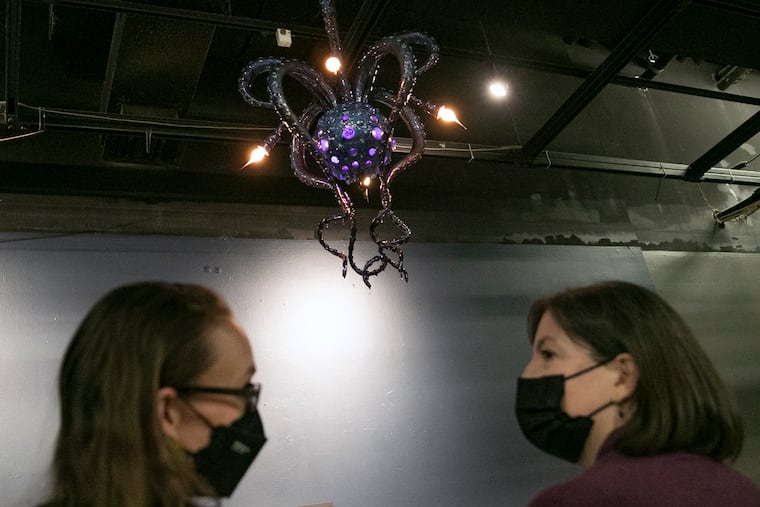 Duguid (left) and Sontchi (right) speak while looking at the octopus chandelier designed by local artist Adam Wallacavage.