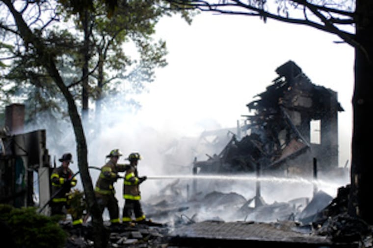 Firefighters battle hotspots in the Sweetwater Casino on the Mullica River after yesterday's early-morning blaze destroyed the landmark Pine Barrens restaurant and banquet hall.