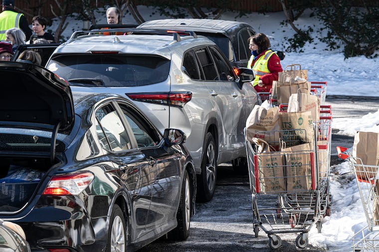 Jenkintown Food Cupboard volunteers pack food into cars outside the United Methodist Church in Jenkintown.