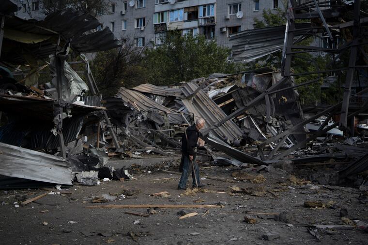 An elderly man walks past a car shop that was destroyed after a Russian attack in Zaporizhzhia, Ukraine, on Tuesday.