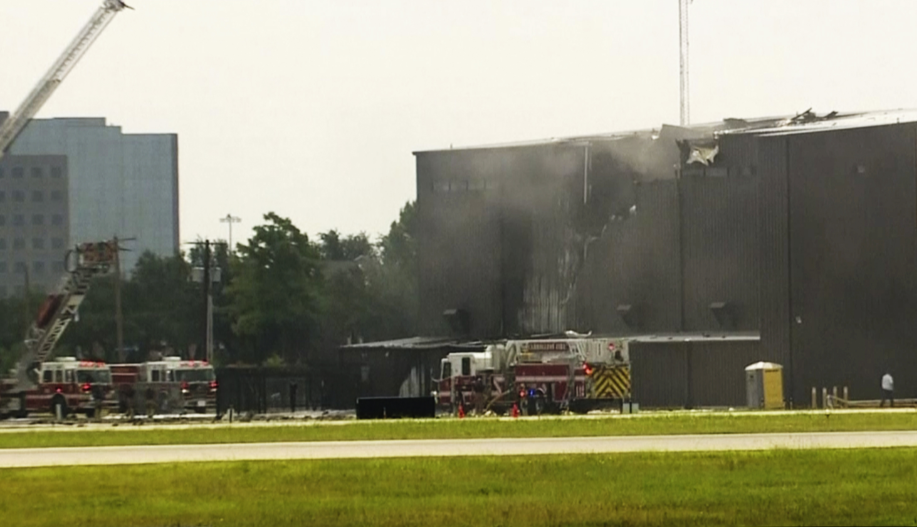 This image made from video provided by WFAA-TV shows responders at a deadly small plane crash at Addison Airport in Addison, Texas, Sunday, June 30, 2019. The small airplane crashed as it was taking off from the Dallas-area airport Sunday morning, a spokeswoman for the town of Addison, Texas, said. (WFAA-TV via AP)