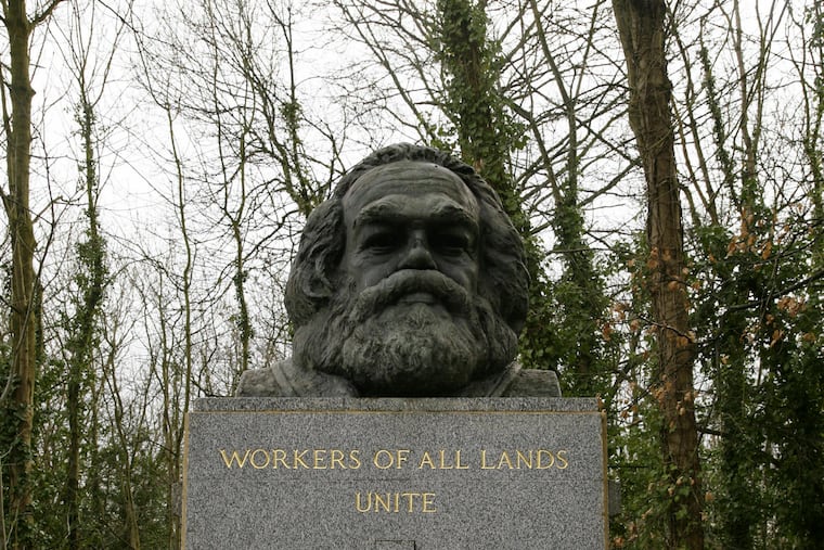 FILE - March 15, 2009 file photo of the grave of Marxist philosopher Karl Marx in Highgate Cemetery, in London. Custodians of a London cemetery say the tombstone of Communist thinker Karl Marx has been damaged in a hammer attack. The German philosopher was buried in Highgate Cemetery after his death in 1883, and his grave was later topped with a large granite bust bearing the words "Workers of all lands unite." (Yui Mok/PA via AP)