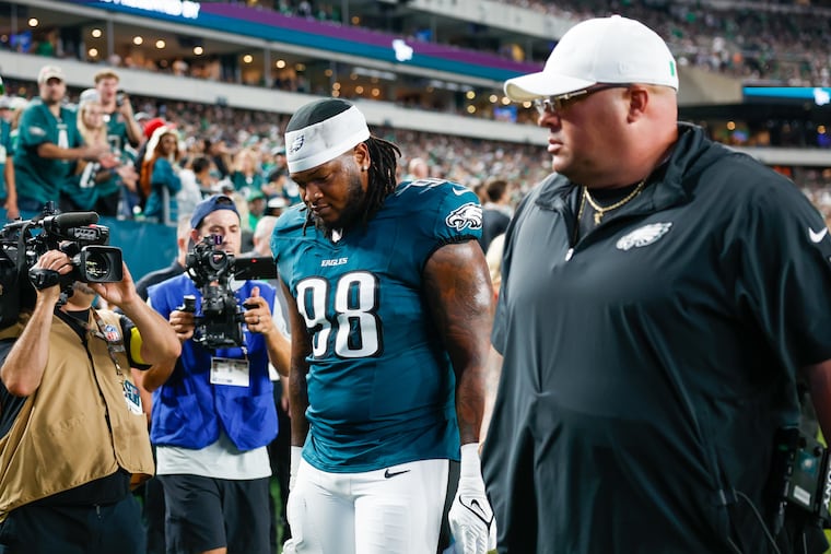 Eagles defensive tackle Jalen Carter leaves the field with security chief Dom DiSandro after being ejected for unsportsmanlike conduct after the opening kickoff against Dallas.