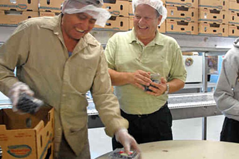 Atlantic Blueberry Co. president Art Galletta (center) talks with packer Francisco Tapia. New Jersey's blueberry farmers have a bumper crop this year.