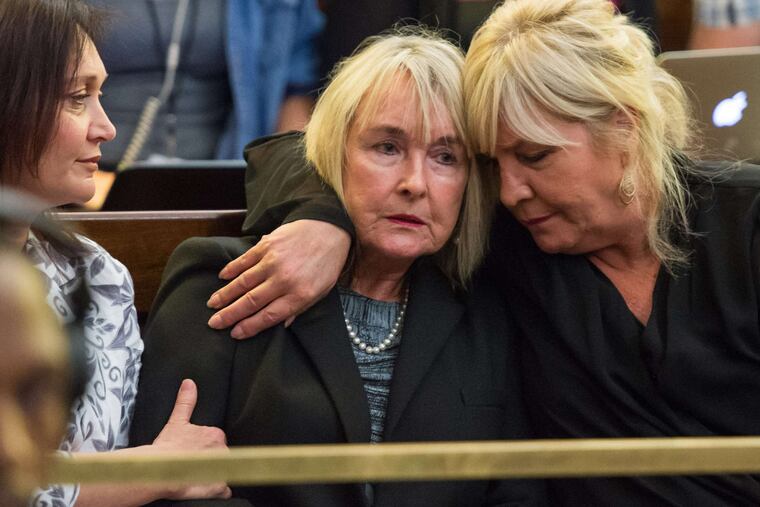 June Steenkamp (center), the mother of Oscar Pistorius' girlfriend Reeva Steenkamp, is comforted as the appeals court delivers the verdict in Bloemfontein, South Africa.