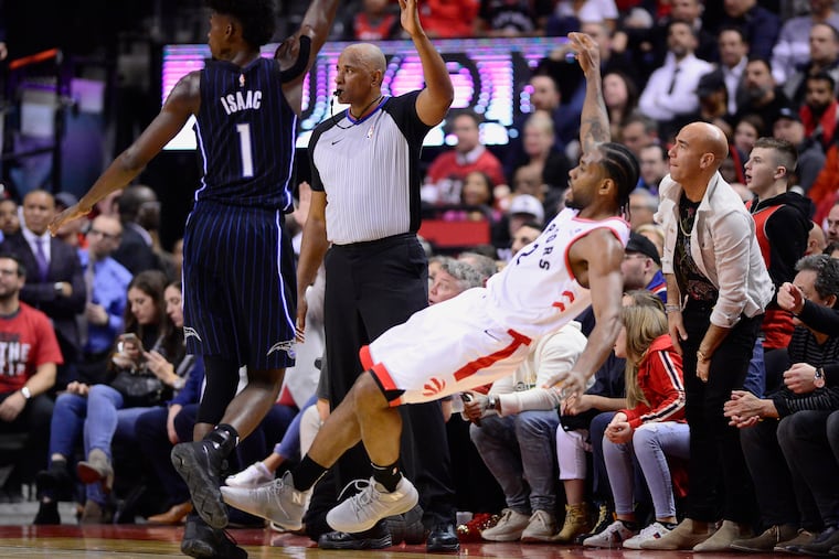 Toronto's Kawhi Leonard fell backward as he drilled a three-pointer over Orlando's Jonathan Isaac during the second half of Tuesday's Game 2. The series shifts to Orlando for Game 3 tonight.