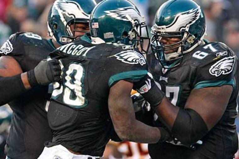 LeSean McCoy got a lift from Nick Cole (left) and Jamaal Jackson (right) after tying the game on a two-point conversion in the fourth quarter of the Eagles' 27-24 win over the Redskins. (Ron Cortes/Staff Photographer)