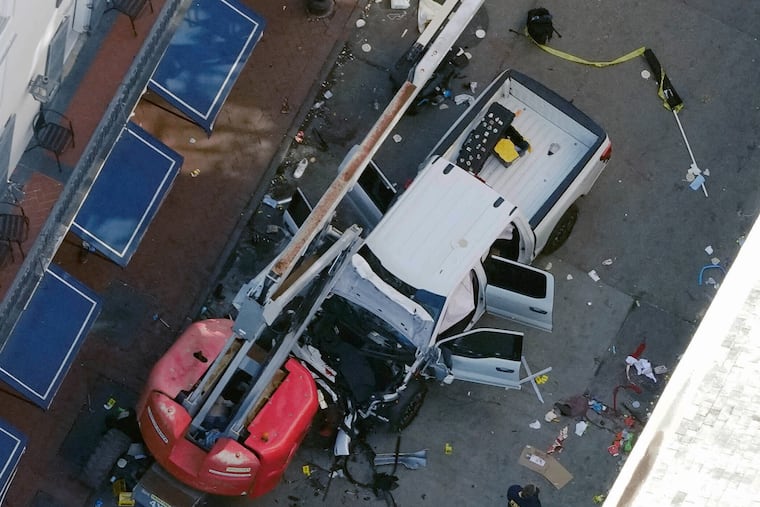 A black flag with white lettering lies on the ground rolled up behind a pickup truck that a man drove into a crowd on Bourbon Street in New Orleans, killing and injuring a number of people on Wednesday.