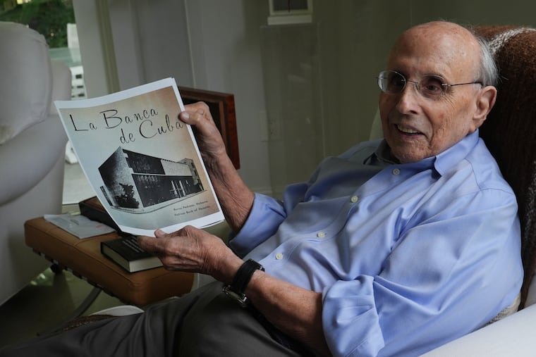 Raul Valdes-Fauli holds a picture of the family-owned Pedroso Bank in Havana during an interview Tuesday, April 21, 2026, in Coral Gables, Fla. (AP Photo/Marta Lavandier)
