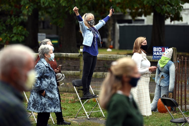 Laura Brenner-Scotti of Northampton stands on a chair to cheer for speaker Jill Biden at a Democratic Get Out the Vote event at Snipes Farm & Education Center in Morrisville, Pa., Oct. 19, 2020.