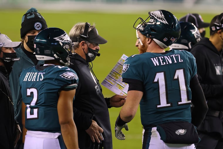 Carson Wentz (11), Jalen Hurts (2) and head coach Doug Pederson during a game in 2020.