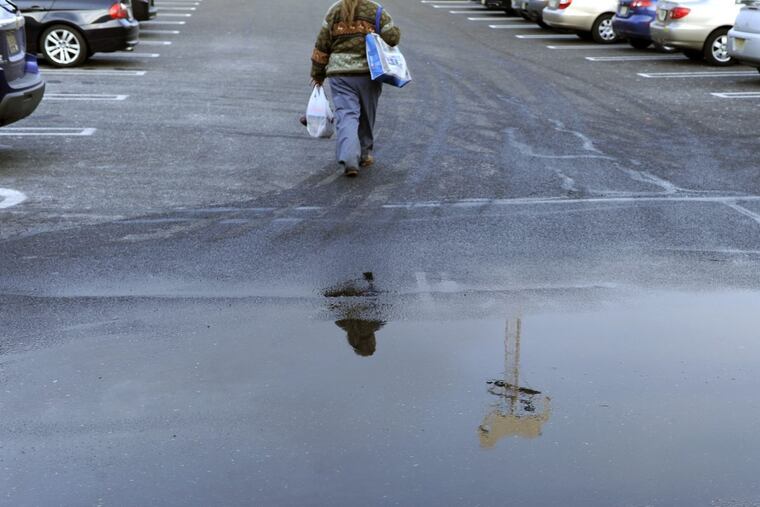 The high white horse landmark sign is reflected in a parking lot puddle in Lawnside.