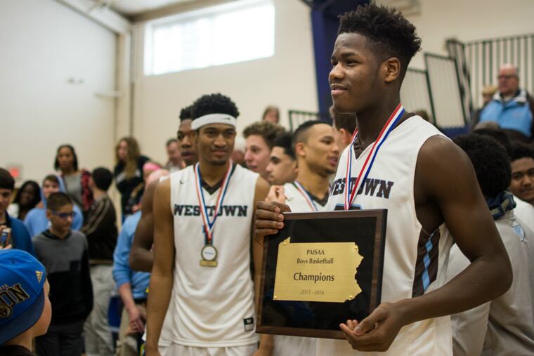 Westtown's Anthony Ochefu holds the PAISAA championship plaque after defeating Germantown 73-65 on Saturday, Feb. 27, 2016.