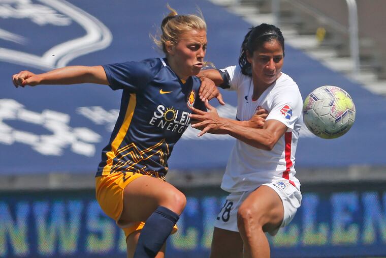 Utah Royals defender Madeline Nolf,left, battles with OL Reign midfielder Shirley Cruz, right, during the first half.