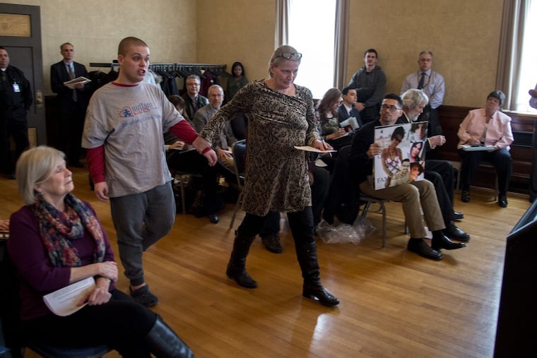 Suzanne O’Mullan, leads her son Danny, who has autism to the podium to testify before the marijuana review panel in Trenton on Feb. 20.