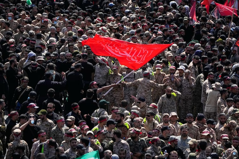 Uniformed members of the Islamic Revolutionary Guard Corps wave a Shiite religious flag during the funeral procession of the slain Iranian Supreme Leader Ayatollah Ali Khamenei and members of his family in Tehran, Iran, Monday, July 6, 2026.